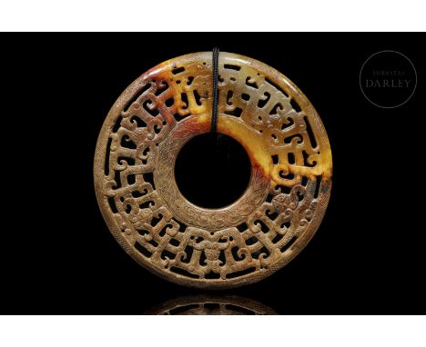 Carved jade pendant, brown in color with reddish, ochre and amber flecks. It is in the form of a disc or ‘Bi’, circular with 