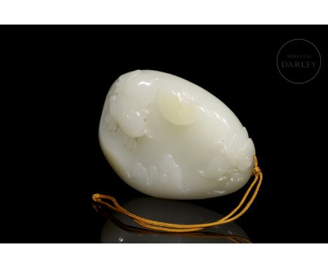 A Hetian carved jade pendant, elegantly white in colour with amber flecks. It has an oval shape with rounded outlines, decora
