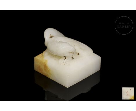 Carved white jade, in the form of a winged mythical beast with a sinuous, coiled body and a fierce gaze, with a tilted head e