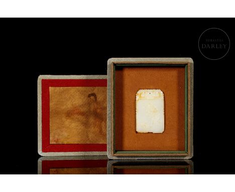 Carved white jade, with subtle reddish and amber flecks. It is rectangular, with cut edges and rounded corners. One side show