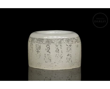 A carved white jade archer's ring (??). It has a slightly irregular profile and a rounded upper edge. It is decorated with ch