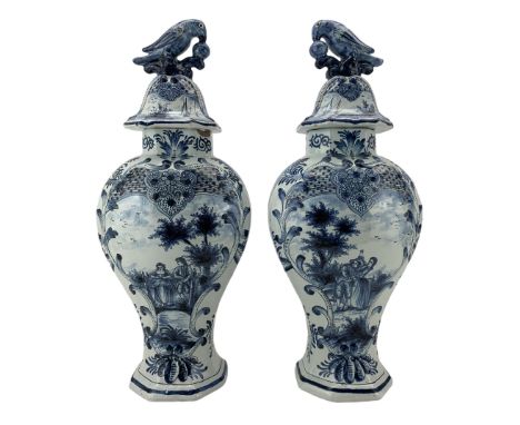 Pair of 20th century Delft vases and covers decorated in blue with figures in rural landscapes, the covers with bird lifts, t