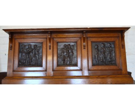 An Oak overmantel set with three Art Nouveau copper panels