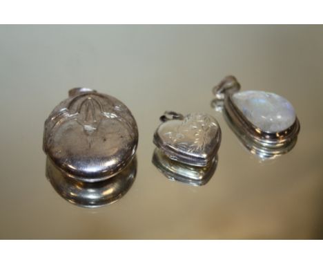 A LARGE STERLING SILVER OVAL LOCKET TOGETHER WITH A HEART SHAPED EXAMPLE AND A MOONSTONE PENDANT