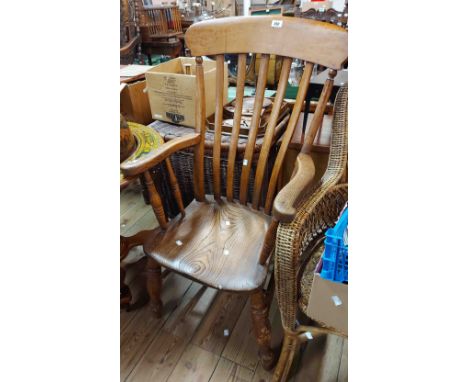 An antique Windsor high lathe back elbow chair with solid moulded elm seat, set on ring turned supports - wear