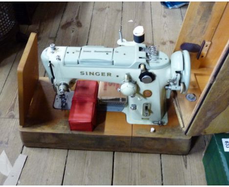 A vintage Singer electric sewing machine in hard carry case