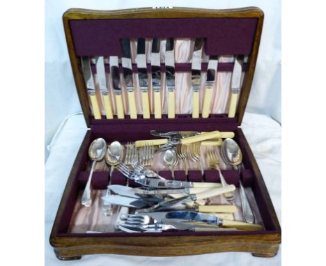 A vintage polished oak canteen containing a part set of silver plated cutlery