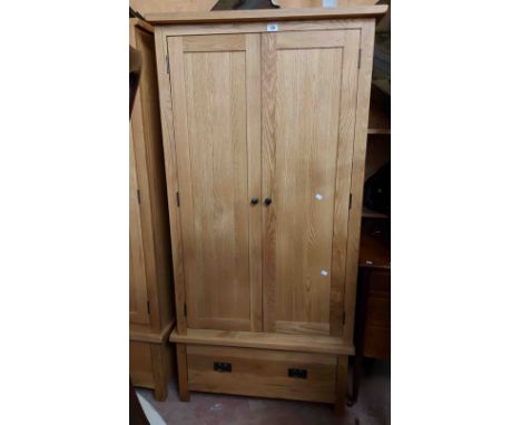 An 89cm modern light oak double wardrobe with hanging space enclosed by a pair of panelled doors with drawer under