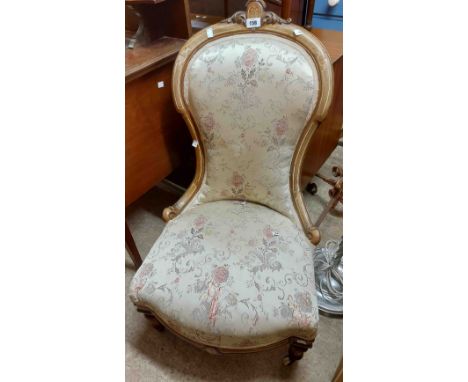 A Victorian mahogany part show frame spoon back nursing chair with machine tapestry upholstery, set on turned front legs and 