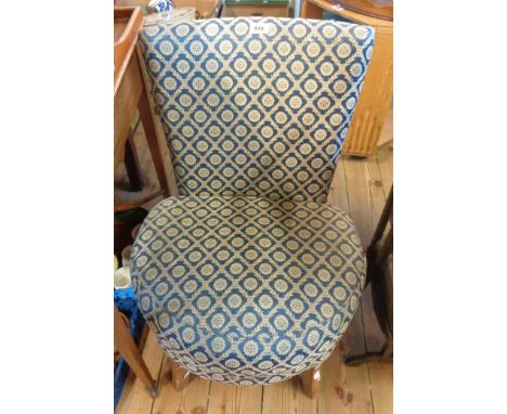 A vintage boudoir chair with blue repeat pattern machine tapestry upholstery, set on polished wood legs