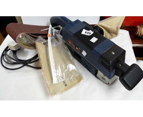 A Bosch belt sander with instructions and spare belts