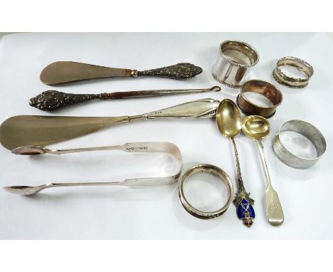 A bag containing four English silver napkin rings and another marked 'sterling', silver mustard spoon and souvenir spoon, als