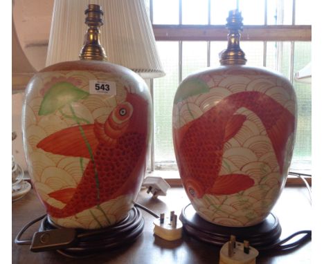 A pair of Chinese style ceramic table lamps with hand painted goldfish decoration, set on turned hardwood stands