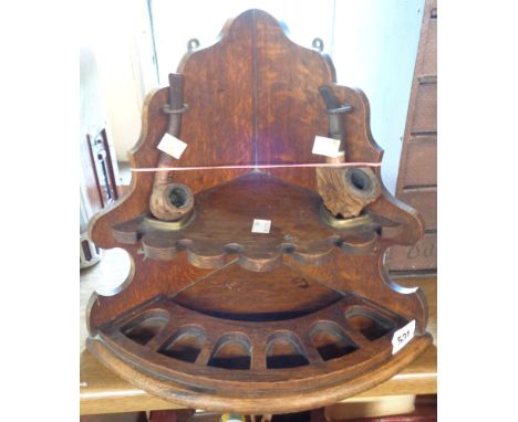 An antique oak corner pipe stand - sold with two pipes