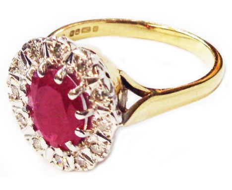 A 375 (9ct.) gold ring, set with central oval ruby within a diamond encrusted border - size O 1/2 - boxed