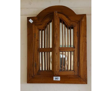 A modern Eastern stained wood framed wall mirror with pair of stick panelled doors to front and shaped plated