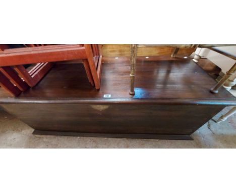 A 1.5m stained hardwood lift-top trunk with flanking heavy drop ring handles by Lombok