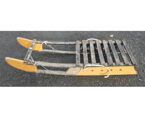 A small decorative painted wooden sled with slatted seat