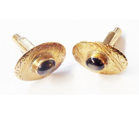 A pair of marked 14k yellow metal cufflinks, set with black chatoyant agate cabochons