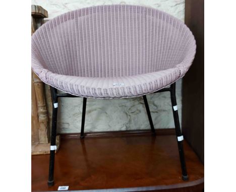 A vintage Lloyd Loom tub chair with original sprayed pink finish and name badge, set on a later metal base