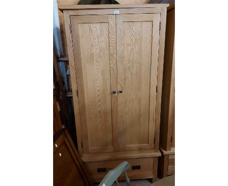An 89cm modern light oak double wardrobe with hanging space enclosed by a pair of panelled doors with drawer under
