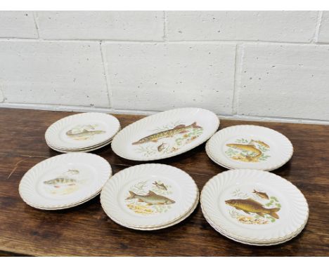 A collection of thirteen French porcelain plates, 24cms diameter, each decorated with different fish; together with a matchin