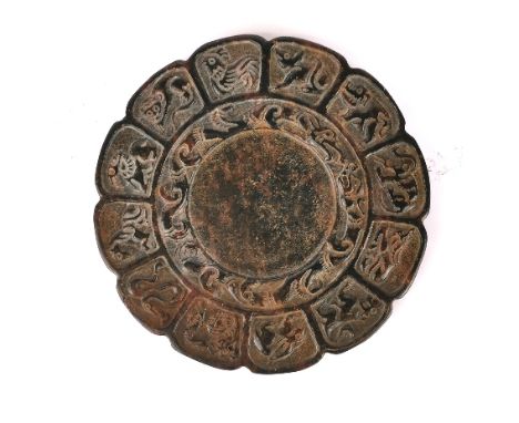 A Chinese carved brown jade/ hardstone ink grinding stone decorated with the twelve year signs, Dia. 8cm.