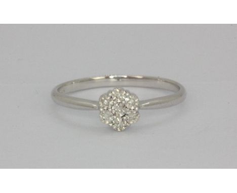 A 9ct white gold diamond set daisy ring, (N.5).