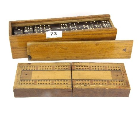 A cased double set of phenolic draughts in a oak case together with an inlaid cribbage board.