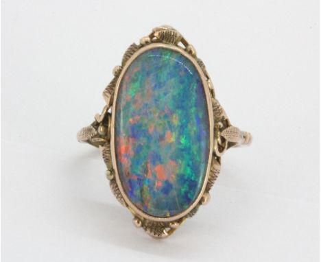 A rose metal ring (tested min 9ct gold)set with a large oval cut triplet opal, (M).&nbsp;Weight - 3.7g.