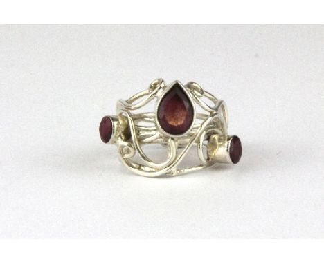 A white metal red stone set ring.