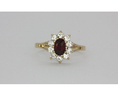 A 9ct yellow gold stone set cluster ring, (M.5).