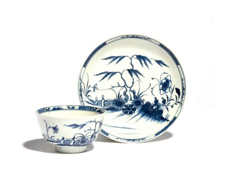 A Worcester blue and white teabowl and saucer c.1760-70, painted with the Candle Fence pattern, an ornamental fence behind a 