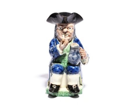 An early creamware Toby jug of Collier type  c.1790, probably Neale &amp; Co., seated with a foaming jug of ale and with a lo