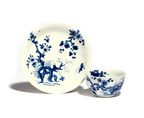 A Worcester blue and white teabowl and saucer  c.1755-58, painted with the Prunus Root pattern, the flowering branches extend