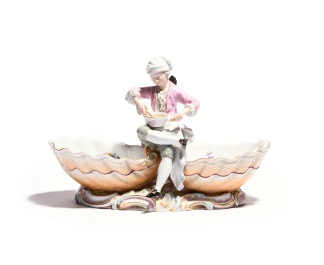 A Meissen sweetmeat figure 19th century, modelled as a young chef seated cross-legged between two large shells and stirring t