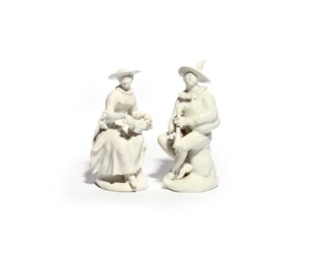 A pair of white-glazed Bow figures of Harlequin and Columbine c.1755-60, seated on rocky stumps, Harlequin playing the bagpip