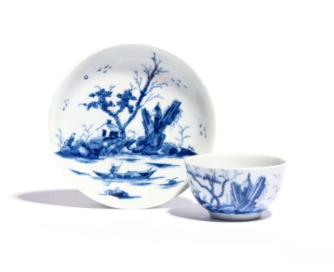 A Worcester blue and white teabowl and saucer c.1755-58, painted with the Gazebo pattern, a small hut protruding from crossed