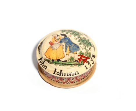 A documentary creamware snuff box and cover  dated 1772, the circular top painted with a couple embracing beneath a tree, ins