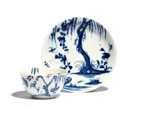 A Worcester blue and white teabowl and saucer  c.1754-56, painted with the Weeping Willow pattern, the gnarled tree above fly