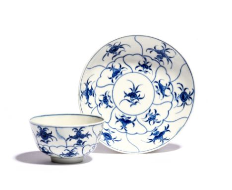 A Worcester blue and white teabowl and saucer  c.1760-70, painted with the Floral Queen's pattern, with bands of shaped panel