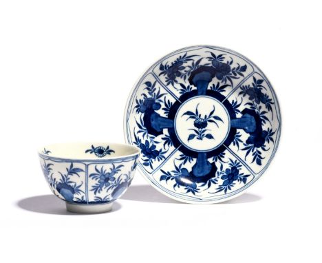A Worcester blue and white teabowl and saucer c.1770-72, painted with the Floral Arcade pattern, with four lotus-petal panels