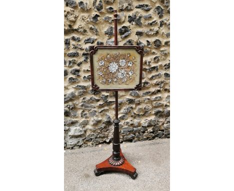 A William IV mahogany pole screen, beaded tapestry floral panel in carved and glazed adjustable frame, turned column and fini