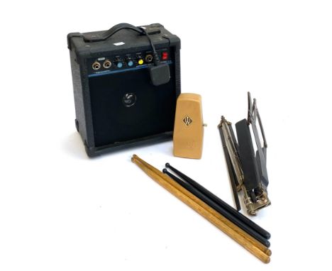A small practise guitar amplifier, music stand, and metronome