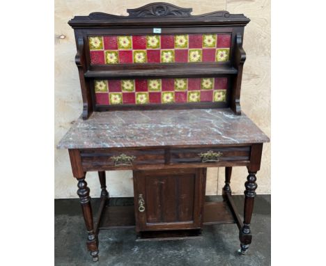 Antique washstand, the art nouveau themed tile back with open shelf above a marble surface, two drawers and central cupboard 