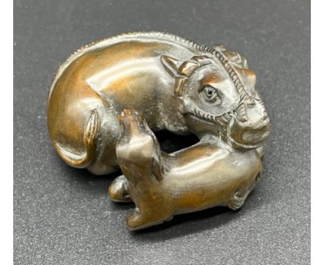 Hand carved Japanese Netsuke sculpture of a An Ox and foal. Signed [4cm in length] 