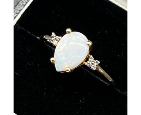 9ct yellow gold ladies ring set with a pear drop cut opal stone off set by blue stone shoulders. [Ring size R1/2] [1.94Grams]