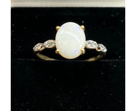 10ct yellow gold ladies ring set with a single oval cut opal off set by white topaz shoulders. [Ring size R] [1.81Grams] 