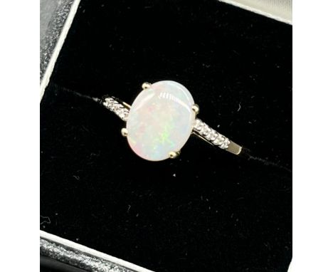 10ct yellow gold ladies ring set with an opal stone off set by white topaz shoulders. [Ring size P] [2.12Grams] 