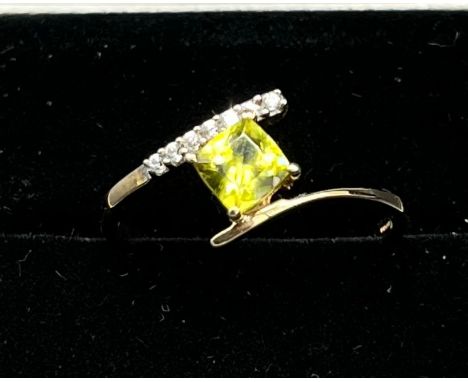 10ct yellow gold ladies ring set with a cushion cut green tourmaline off set by seven white topaz stones. [Ring size P] [1.80